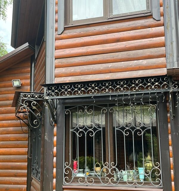 Кованая решётка на окно и цветочница для деревянного дома