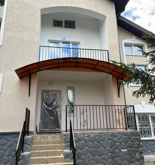 Входная группа с арочным козырьком и балконным ограждением